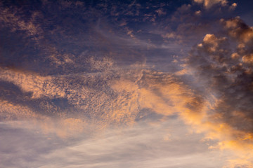 Beautiful small clouds during the sun fall. The golden hour paints the clouds of warm colors.