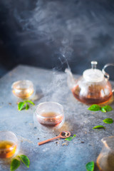 Steaming hot tea in a glass bowl, morning light breakfast scene