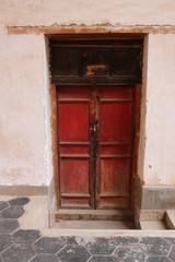 Fototapeta na wymiar Red wooden door of an Old House.