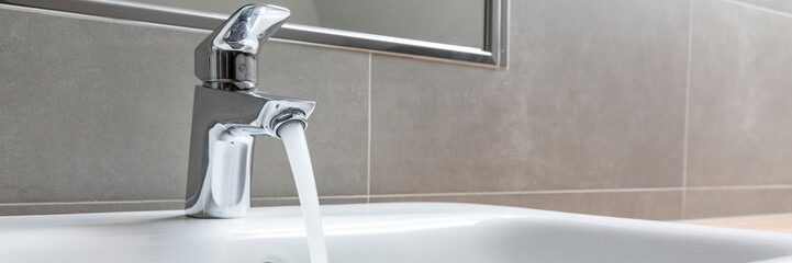 faucet with running water in modern bathroom