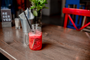 Woman hand holding smoothie shake on the table in a cafel. Drinking healthy smoothie concept.