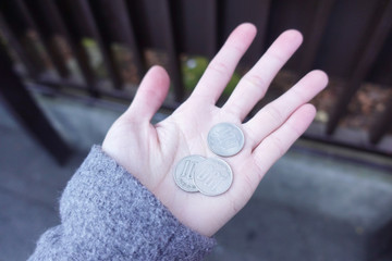 Close up of a female hand holding three hundred yen coins