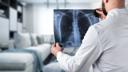 Naklejka na ściany i meble Doctor holding radiography x ray photo on hospital background