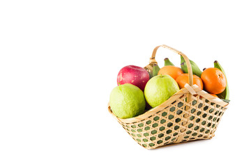 orange, green guava, banana and red apple in bamboo wicker basket on white background fruit health food isolated