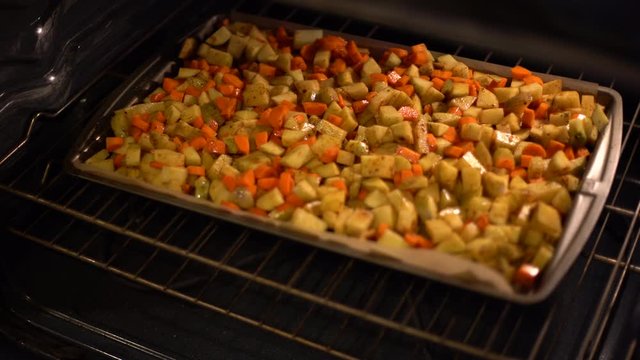 4K image of carrots and potatoes roasting in the oven