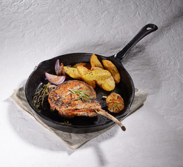 grilled pork steak tomahawk in a pan on bright background