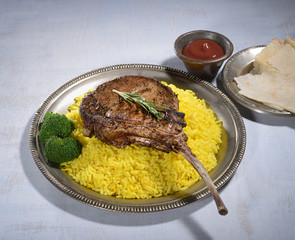 Tomahawk pork steak with rice on a gray background