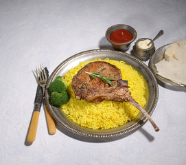 Tomahawk pork steak with rice on a gray background