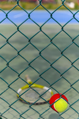 tennis ball stuck on the wire fence of a outdoor court vertical composition