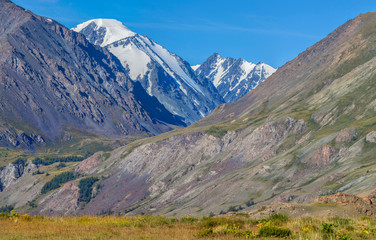 Fototapeta premium Mountain view, sunny day. Snow-capped peaks, gorge. Traveling in the mountains, climbing.