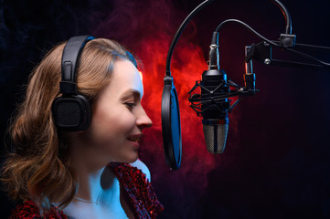 Vocal teacher singing with a studio microphone in a studio with a bright background. Teaching...