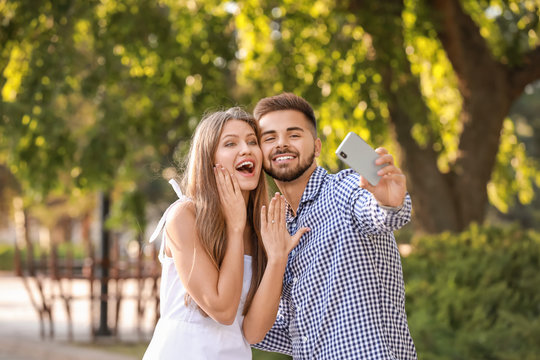 Happy Engaged Couple Taking Selfie Outdoors