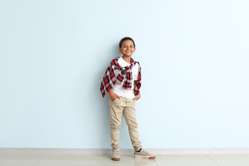 Fototapeta premium Cute fashionable African-American boy on color background