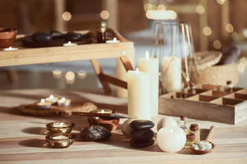 Glowing candles with spa supplies on table