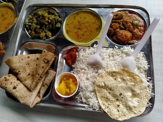 A typical north Indian thali consisting of multiple bowls full of vegetables and curries. Complete meal food served in the hostel canteen.