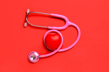 Modern stethoscope and red heart on color background