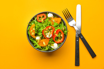 Plate with tasty salad on color background