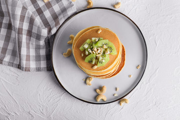 Plate with stack of tasty pancakes on table