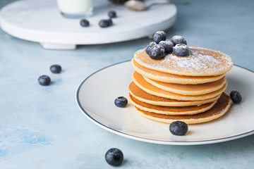 Plate with stack of tasty pancakes on table