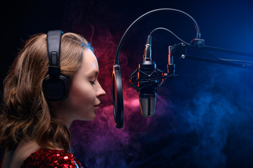 Vocal teacher singing with a studio microphone in a studio with a bright background. Teaching vocals and solo singing. Soundtrack and album recording