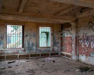 Fototapeta na wymiar Abandoned prison jail building complex with graffiti and broken foundation