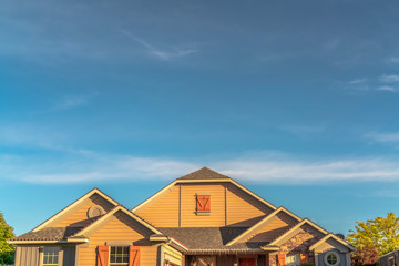 House exterior with view of the gable roof with gable windows against blue sky
