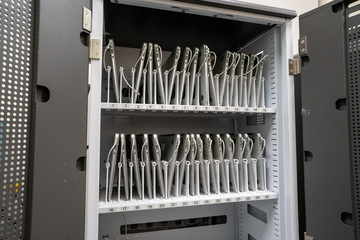Rows of laptop computers charging in storage drawer in an enterprise of education classroom setting