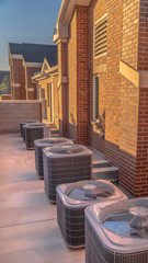 Vertical Close up of air conditioners at the exterior of a building with red brick wall