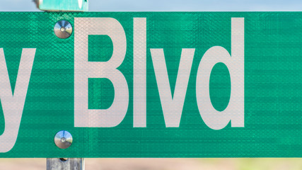 Obraz premium Panorama frame Selective focus on a green and white road street sign that reads Blvd