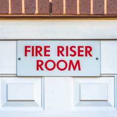 Square frame Close up of the Fire Riser Room with white wooden door of a brick building