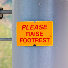 Square frame Please Raise Footrest sign on chairlifts in Park City Utah viewed at off season