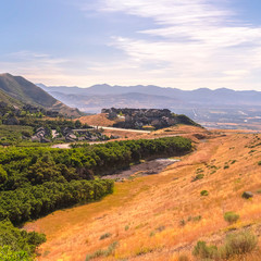 Fototapeta premium Square Scenic mountain landscape with houses amidst vast slopes covered with greenery