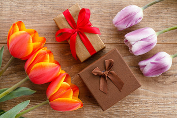 Gift boxes with red ribbons on wooden boards.