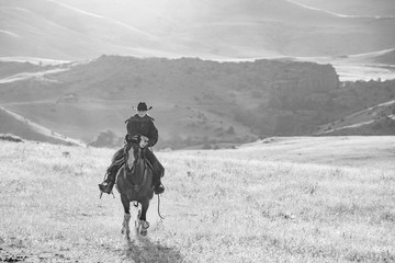 black and white horseback riding in mountains