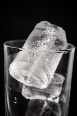 glass of water with ice on black background