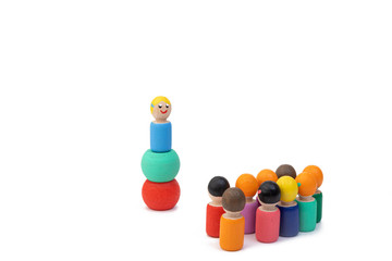 Wooden toys stand and wait for commands from their male leader. The image of building a team in...