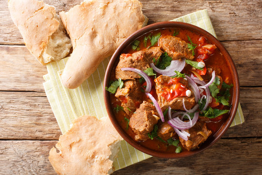 Georgian beef stew with spices in tomato sauce close-up in a bowl. Horizontal top view