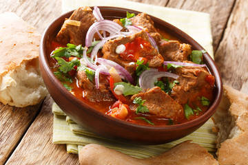 Chashushuli is a traditional Georgian beef stew with tomato sauce close-up in a bowl. horizontal