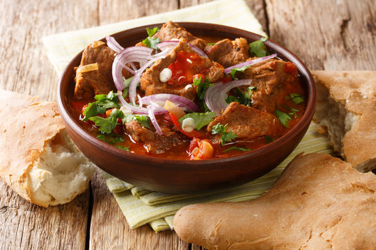 Georgian beef stew with spices in tomato sauce close-up in a bowl on the table. horizontal