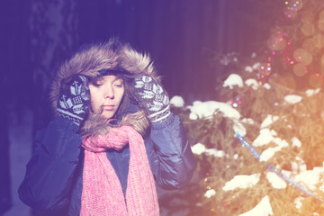 young caucasian girl\woman in the winter snow-covered forest at the Christmas tree