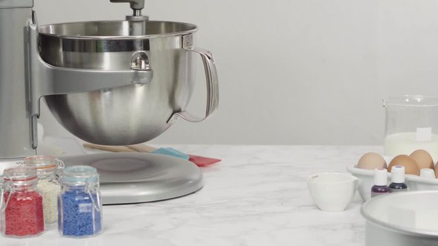 Step by step. Mixing ingredients in standing kitchen mixer to bake a three-layer vanilla cake.