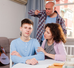 Teenager listening to reprimanding parents