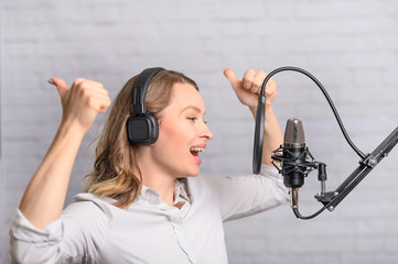 Emotional reading a girl news on the radio, in the studio with a studio microphone. Podcasts,...