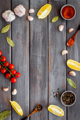 Kitchen frame with spices and food - pepper, garlic, tomatoes - on dark wooden background top-down frame copy space