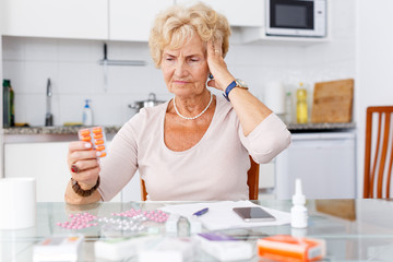 Confused woman among a lot of medicines