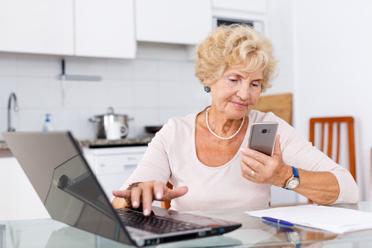 Woman using computer and smartphone