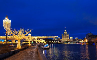Fototapeta na wymiar View of Christmas Moscow with a soaring bridge over the Moscow river, new year installations and a high-rise building on Kotelnicheskaya embankment on the horizon. Russia