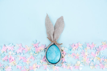 Easter background with blue and white eggs in nest and yellow tulips. Top view with copy space