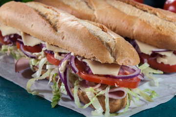 Submarine sandwiches with ham, cheese and vegetables