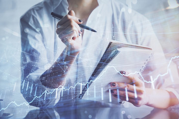 Financial chart drawn over hands taking notes background. Concept of research. Multi exposure